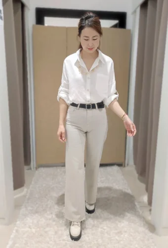 mujer con camisa blanca y pantalón gris