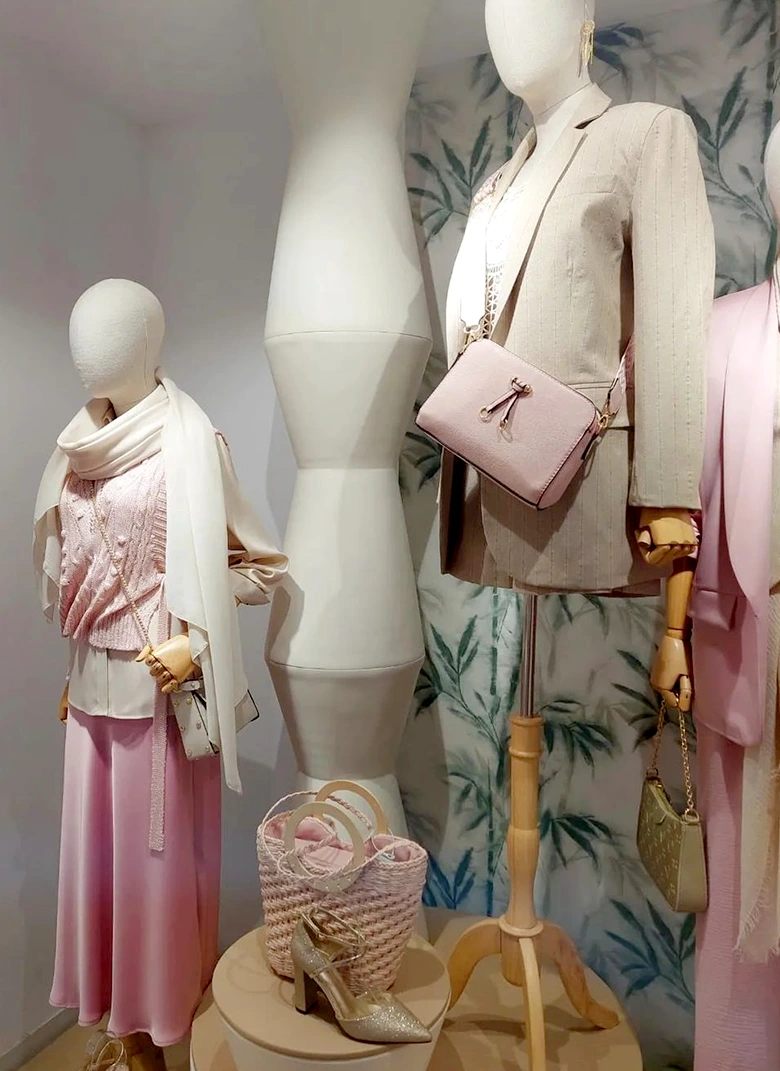 maniquís en escaparate con prendas de tonos rosas