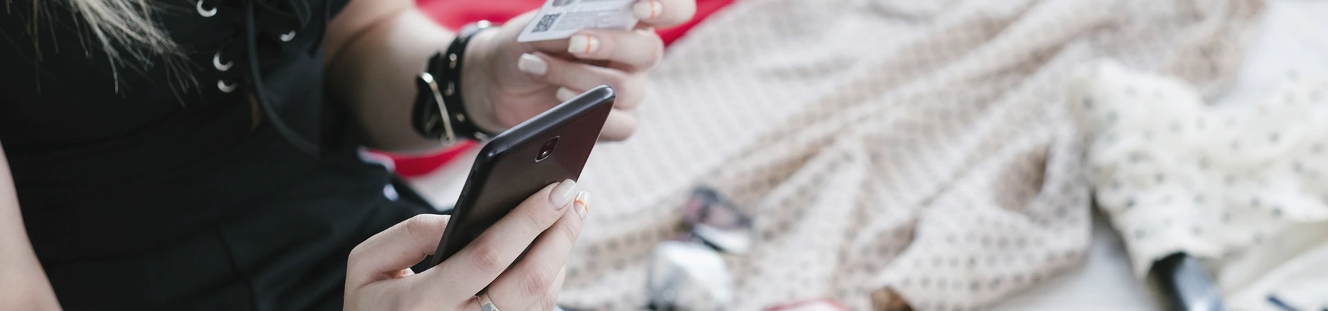 manos sujetando móvil y tarjeta de crédito